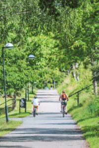 man in red shirt riding bicycle on road during daytime