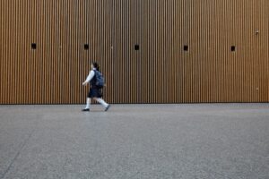 woman in uniform walkin on gray concrete pavement during daytime