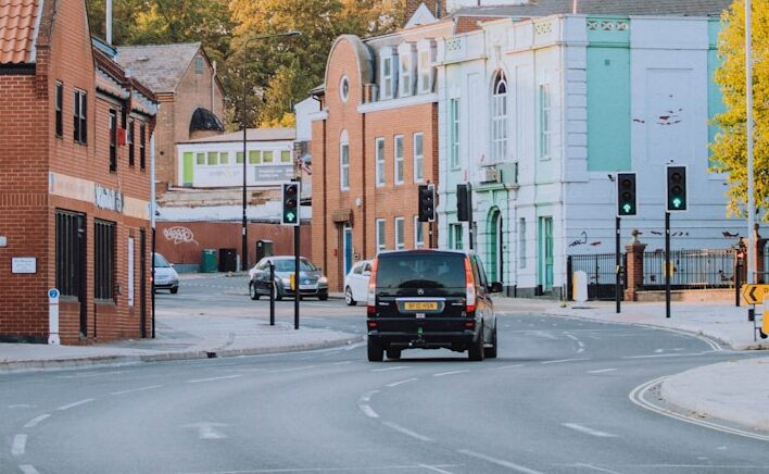 a car driving down a street next to tall buildings