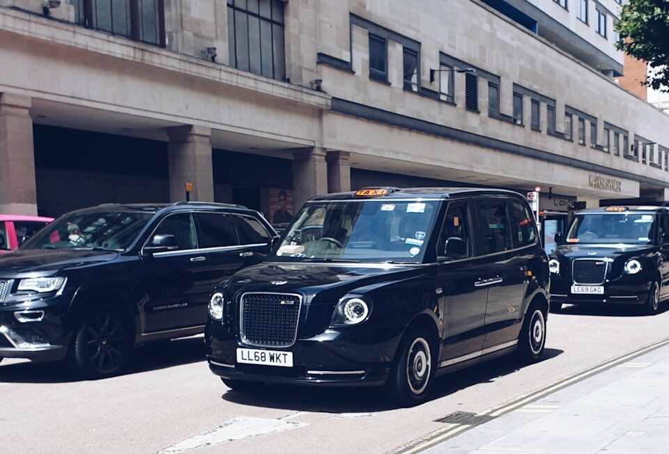 black mercedes benz g class parked on sidewalk during daytime