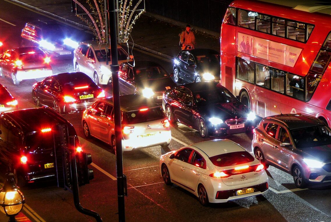 a red double decker bus driving down a street