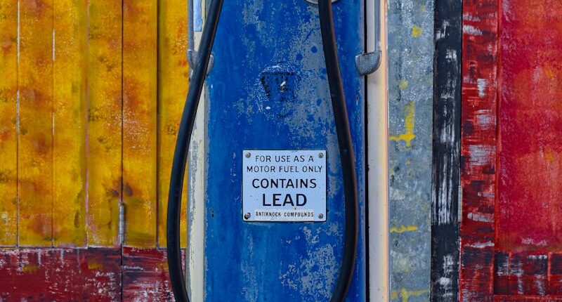 Vintage blue gas pump in front of a vibrant, weathered wall. Classic retro style.