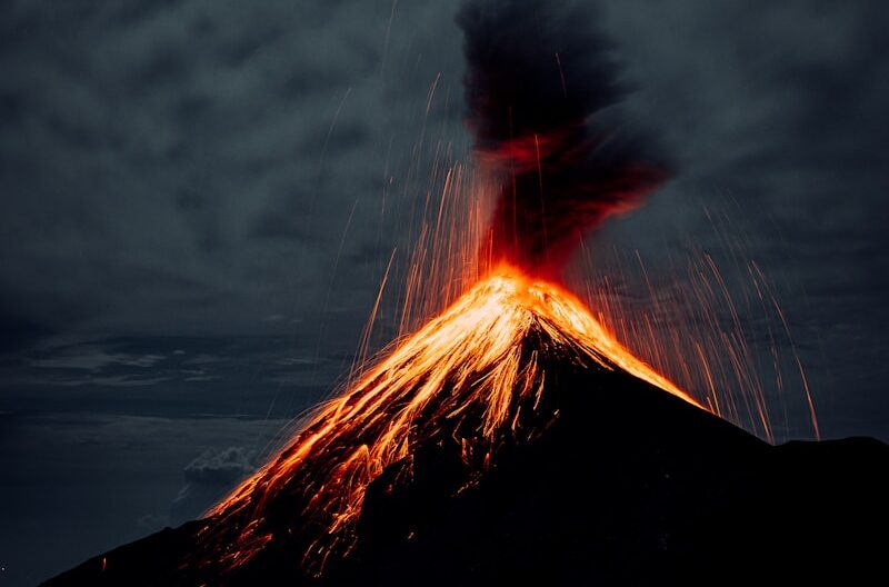 a silhouette of a person with a fire in the background