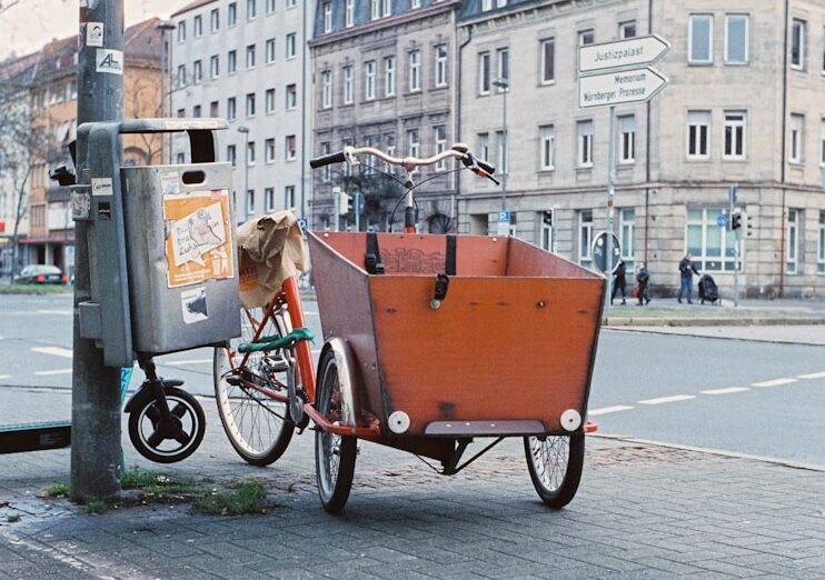 a bike with a trailer attached to it parked on the side of a street